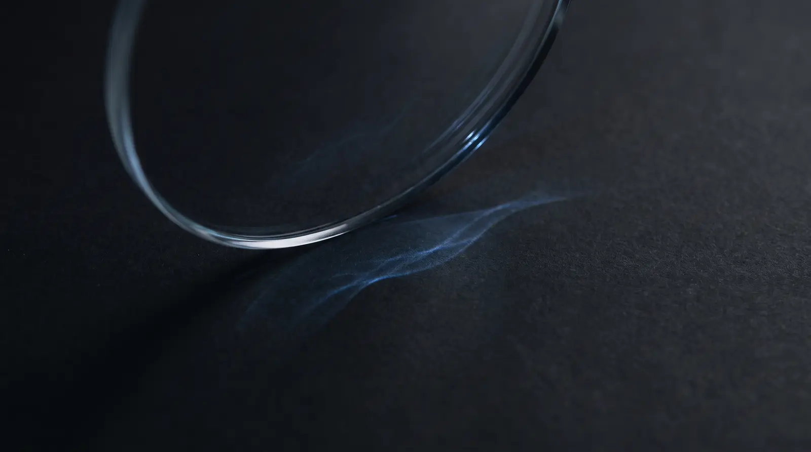 Macro of curved optical glass with subtle blue light refraction